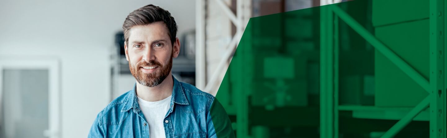 Header: Ein Mann mit weißem T-Shirt und blauem Hemd lächelt in die Kamera