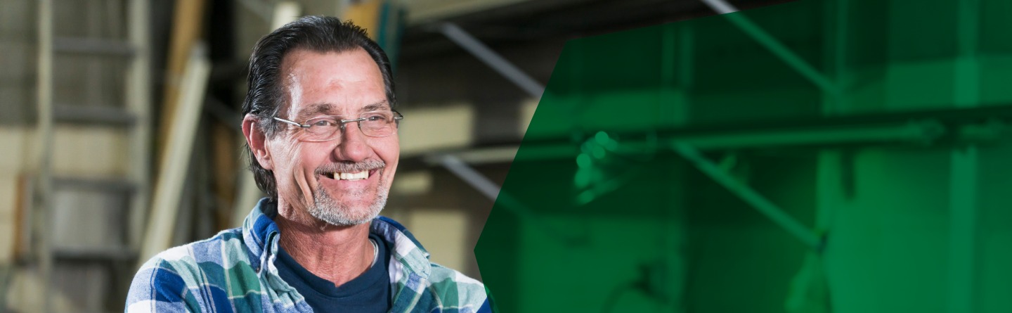 Header: Ein Mann mit Brille und kariertem Hemd lächelt in die Kamera